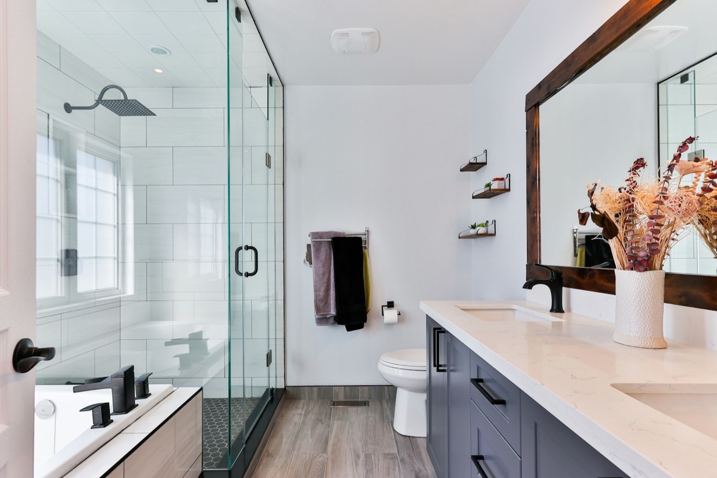 A white bathroom with a glass shower, a floating vanity and a large mirror